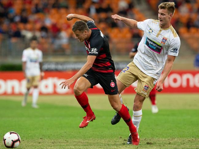 Wanderers striker Oriol Riera (left) is challenged by Newcastle’s Lachlan Jackson on Friday night. Picture: AAP