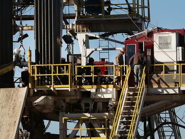 MIDLAND, TX - JANUARY 20: Workers stand on the platform of a fracking rig in the Permian Basin oil field on January 21, 2016 in the oil town of Midland, Texas. Despite recent drops in the price of oil, many residents of Andrews, and similar towns across the Permian, are trying to take the long view and stay optimistic. The Dow Jones industrial average plunged 540 points on Wednesday after crude oil plummeted another 7% and crashed below $27 a barrel.   Spencer Platt/Getty Images/AFP