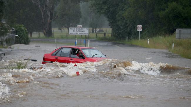 A car drives into flash flooding at Telegraph Point, north of Port Macquarie on Friday. Picture: Nathan Edwards