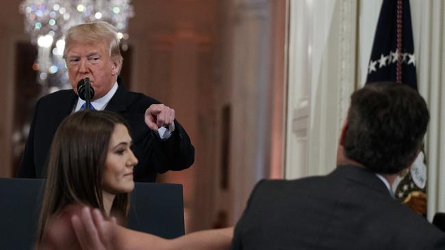 President Donald Trump watches as a White House aide reaches to take away a microphone from CNN journalist Jim Acosta during the fiery news conference. Picture: Evan Vucci/AP