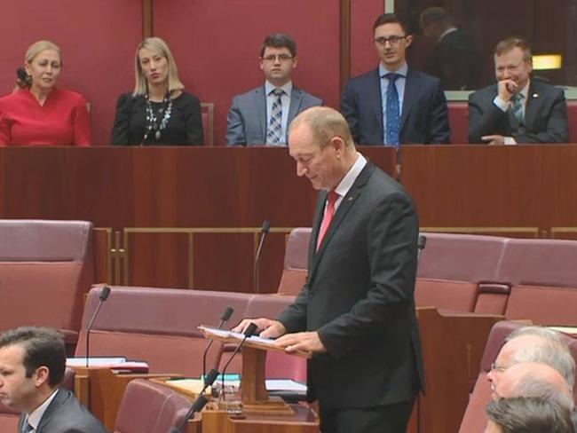 Speechwriter Richard Howard, far right, watches Senator Fraser Anning deliver his first speech to the Senate.