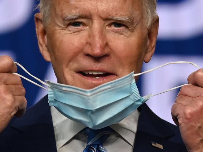 (FILES) In this file photo former Democratic Presidential candidate Joe Biden removes his facemask as he arrives to speak at the Chase Center in Wilmington, Delaware, on November 4, 2020. - US President-elect Joe Biden on November 9, 2020 named the scientists who will lead his administration's response to the coronavirus pandemic, signaling his plans to prioritize Covid-19 from the outset. The advisory board will be led by three co-chairs: epidemiologist and former Federal Drug Administration (FDA) commissioner David Kessler, former surgeon general Vivek Murthy, and Yale public health professor Marcella Nunez-Smith, according to a statement from the Biden transition team. (Photo by JIM WATSON / AFP)