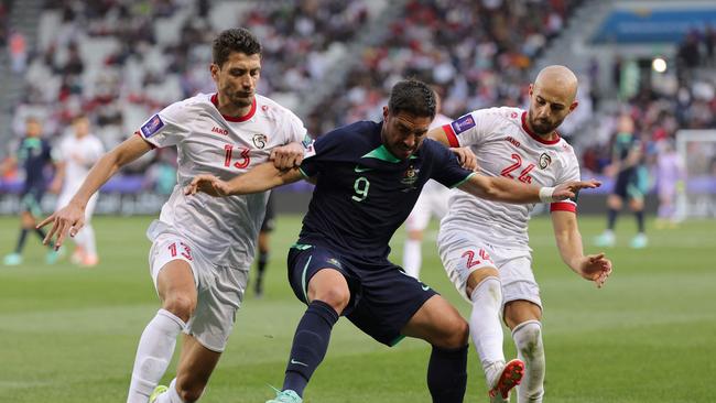 Syria's Thaer Krouma and defender Abdul Rahman Weiss vie for the ball against Australia's Bruno Fornaroli. Picture: Giuseppe Cacace / AFP.