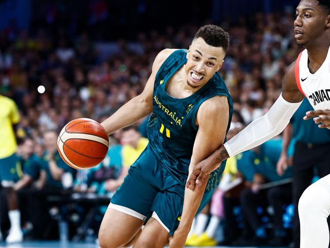 Australia's #11 Dante Exum outflanks Canada's #09 Rj Barrett in the men's preliminary round group A basketball match between Canada and Australia during the Paris 2024 Olympic Games at the Pierre-Mauroy stadium in Villeneuve-d'Ascq, northern France, on July 30, 2024. (Photo by Sameer Al-Doumy / AFP)