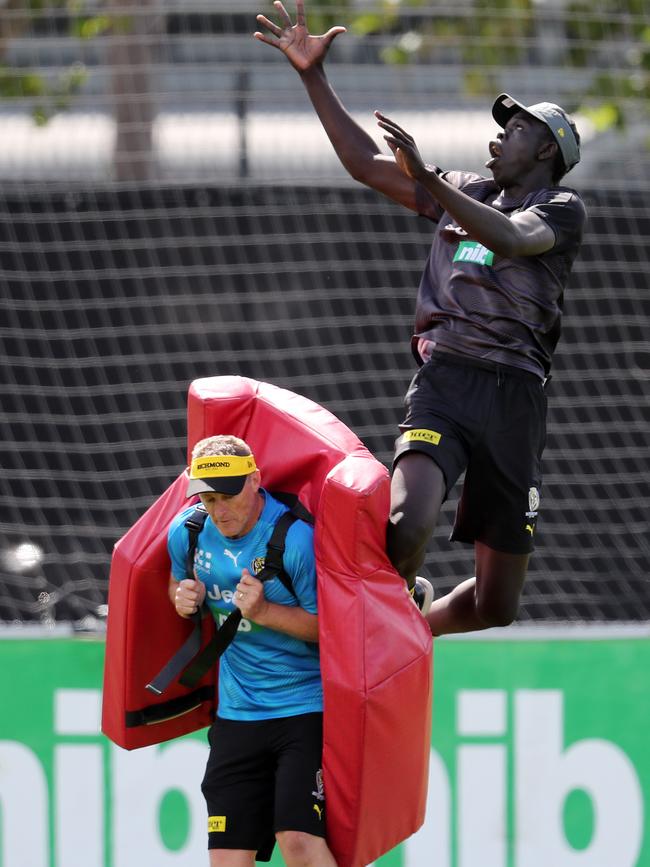 Bigoa Nyuon takes a leap over coach Damian Hardwick. Picture: Michael Klein