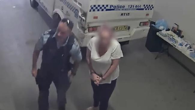 Georgie Marks being taken inside Raymond Terrace police station after being arrested over the alleged screwdriver at Nelson Bay. Picture: NSW Police.