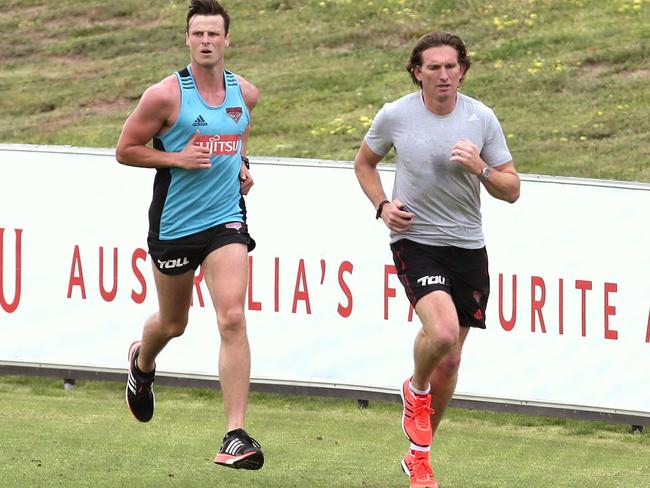 James Hird runs laps with Alex Browne on Monday morning at Essendon’s Tullarmarine training facility. Picture: Hamish Blair