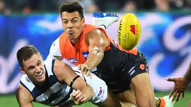 Geelong’s Joel Selwood gets a handball away under pressure from GWS’s Dylan Shiel on Friday night.