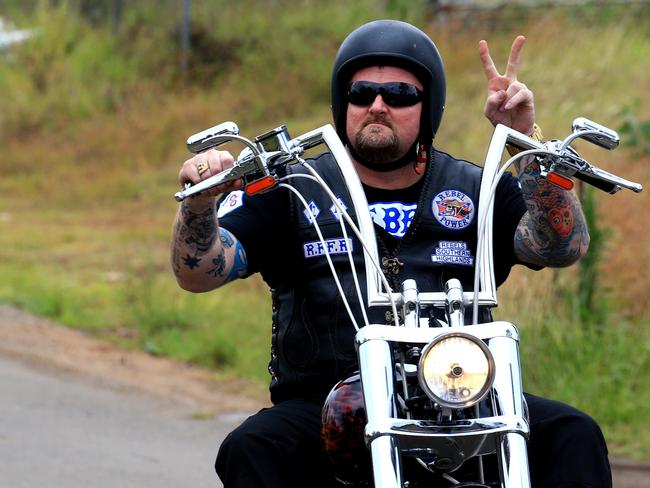 A Rebels bikie gives the peace sign after the funeral. Picture: Adam Taylor