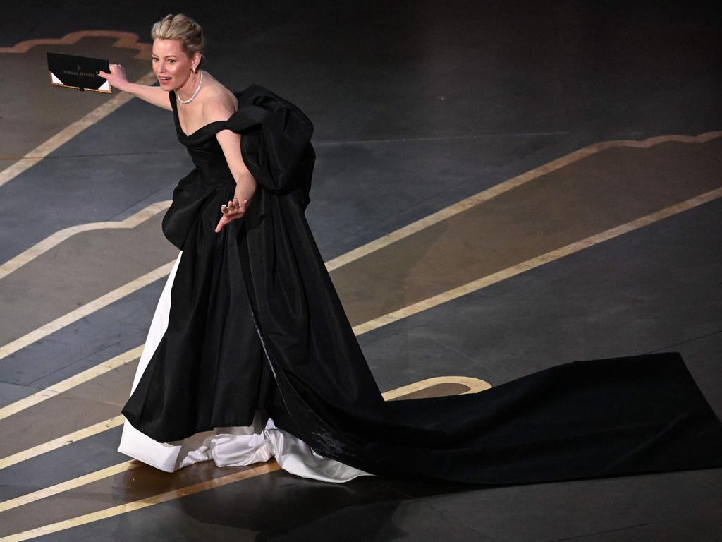 Elizabeth Banks trips on stage at the Oscars. (Photo by Patrick T. Fallon / AFP)