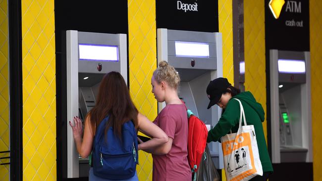 Customers use a Commonwealth Bank (CBA) ATM in Brisbane, Thursday, August 3, 2017. The Commonwealth Bank has been accused of a systemic failure to comply with anti-money laundering and counter-terrorism financing laws. The federal government's financial intelligence unit AUSTRAC on Thursday launched civil penalty proceedings in the Federal Court, accusing the lender of more than 53,700 contraventions of law. (AAP Image/Dan Peled) NO ARCHIVING