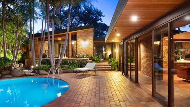 The living, kitchen and dining rooms all open out to the natural spring pool surrounded by lush, tropical plantings.