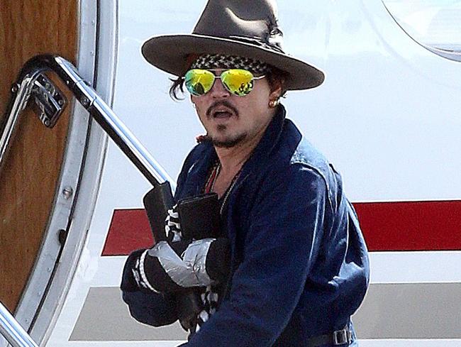 Johnny Depp, with a bandaged hand, boards a private jet in Brisbane, Australia.
