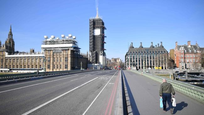 An empty Westminster Bridge with one pedestrian on the pavement in central London on March 24, 2020 after Britain ordered a lockdown to slow the spread of coronavirus. Picture: Justin Tallis / AFP