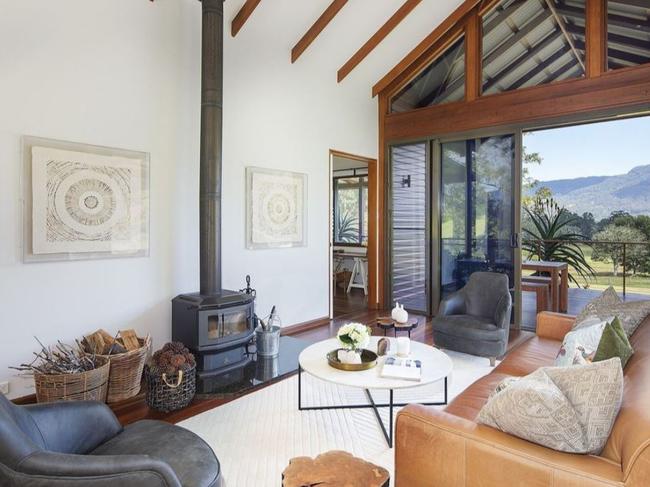 An open-plan living space has a pitched beamed ceiling.