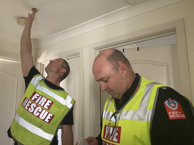 Senior Firefighter Rhett Davis and Superintendant of metropolitan South 3 zone commander Greg Wright installing a free smoke detector at a Liverpool residence.