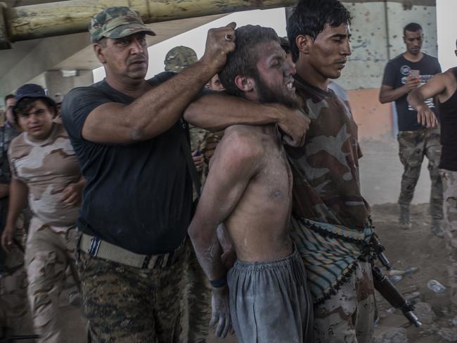 A man suspected of being an Islamic State militant is detained by the Iraqi Army in Mosul last week. Picture: Martyn Aim/Corbis/Getty Images