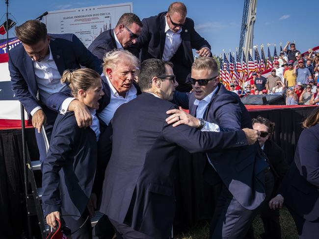 Secret Service agents remove Donald Trump from the stage with blood on his face during a campaign rally in Pennsylvania where he was shot in the ear. Picture: Getty Images