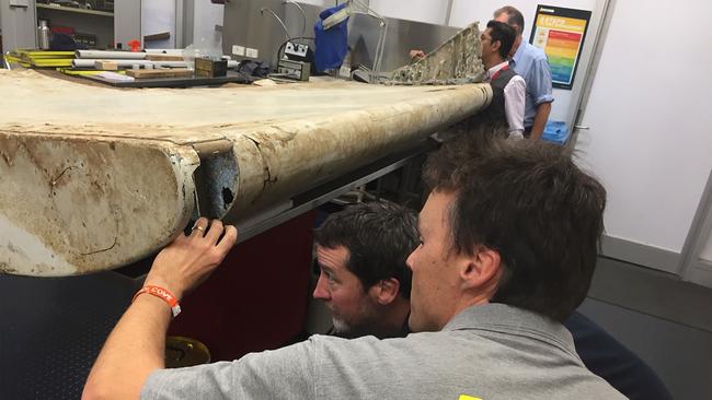 Malaysian and Australian investigators examine a piece of aircraft debris found on Pemba Island off the coast of Tanzania. Picture: AFP