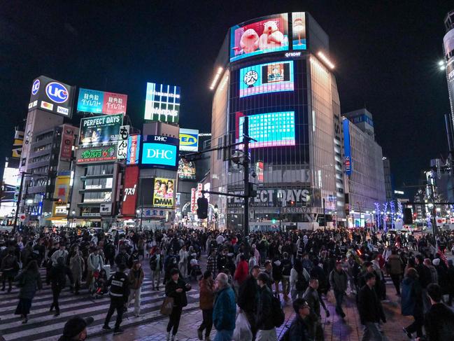 People walk across Shibuya Crossing a few hours before midnight in central Tokyo on December 31, 2023. Picture: Richard A. Brooks / AFP