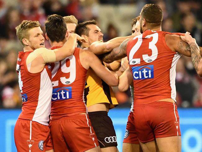 Lance Franklin of the Swans and Luke Hodge of the Hawks push and shove.