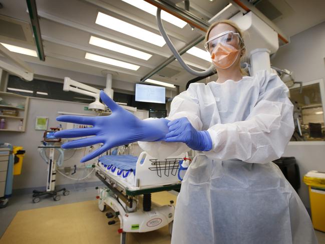 Associate Nurse Manager Michelle Caulfield putting on her PPE (personal protection equipment) in the Alfred Hospital Emergency Department. Picture: David Caird