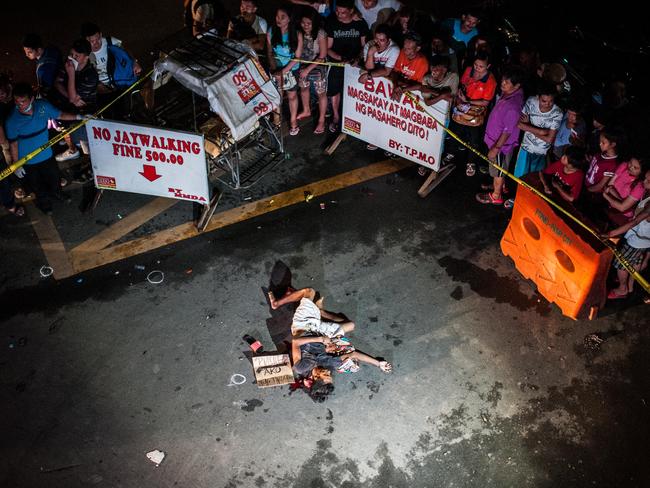 An alleged drug dealer lies dead in a street execution in Manila.