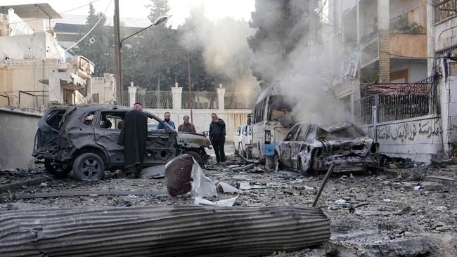 People check damage at the scene of a Syrian regime airforce strike that targeted a neighbourhood in Syria's rebel-held northern city of Idlib.