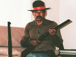 Ivan Milat wearing a sheriff’s badge in his lounge room with a shotgun. Picture: Supplied