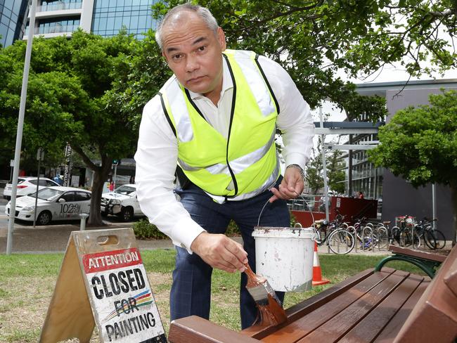 Gold Coast Mayor Tom Tate paints over grafitti on a park bench in Southport. Picture: Tertius Pickard.
