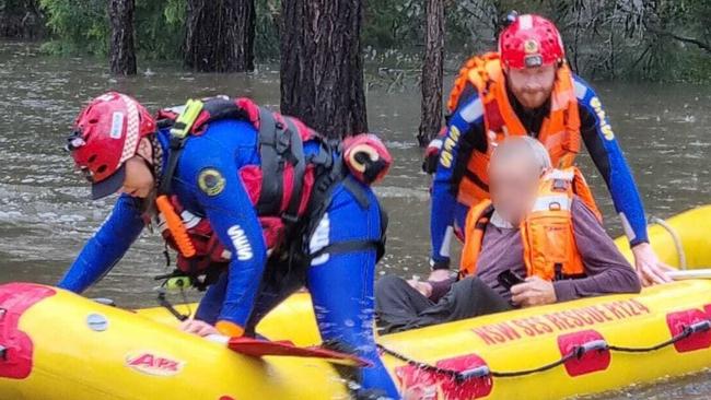 SES personnel rescue a man from floodwaters in Liverpool. Picture: Liverpool SES