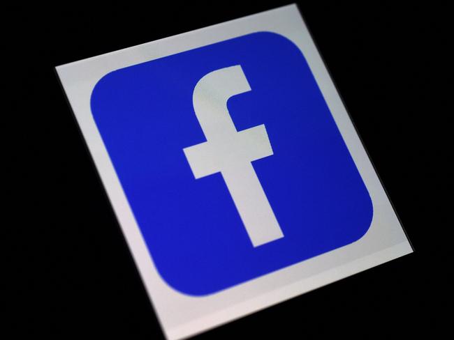 (FILES) This file photo illustration shows a Facebook App logo  displayed on a smartphone on March 25, 2020 in Arlington, Virginia. - Facebook said on February 18, 2021, it would expand its climate information hub and direct its users to experts to debunk myths and hoaxes in the field in a ramped up effort to fight misinformation. (Photo by Olivier DOULIERY / AFP)