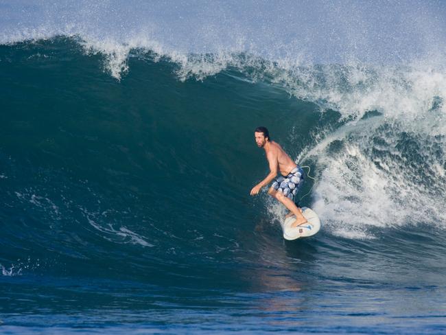 Former surf shop owner Richard Johnston riding the waves in Canggu on the south coast of Bali.