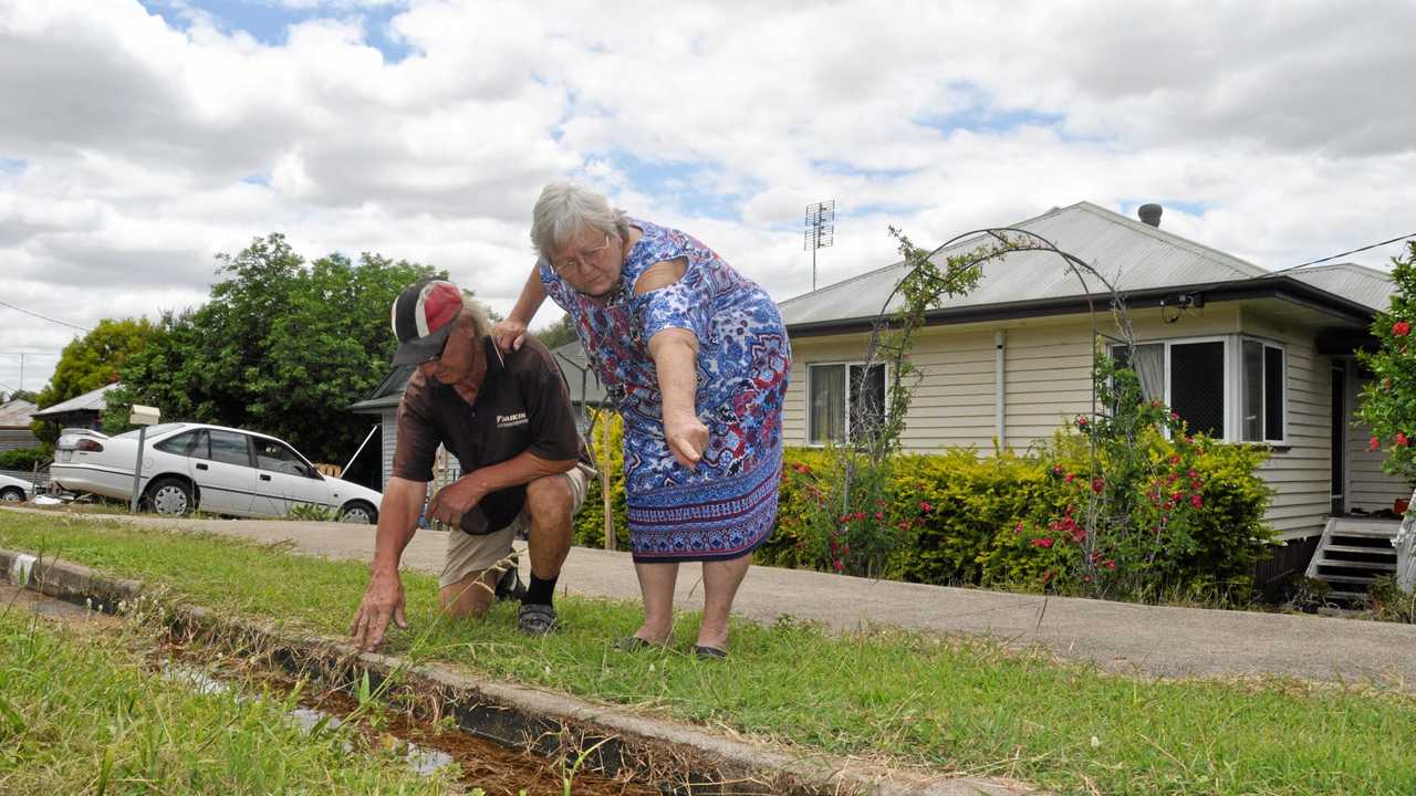 Brian White and Debbie O&#39;Sullivan inspect the out-of-shape gutter in front of their houses. Picture: Mackenzie Colahan