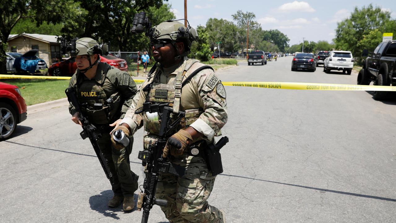 Law enforcement personnel run away from the scene of a suspected shooting. Picture: Reuters/ Marco Bello