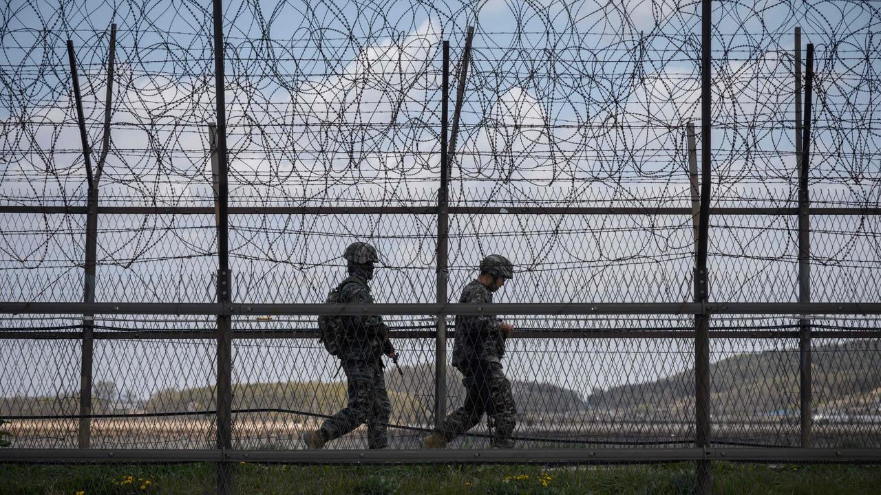 South Korean soldiers patrolling along a barbed wire fence at the Demilitarised Zone (DMZ) separating North and South Korea. Picture: Ed Jones / AFP