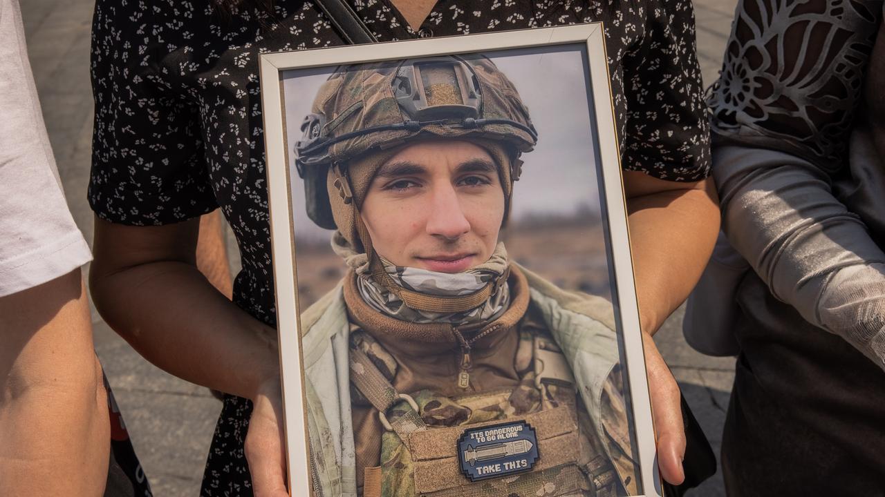 A relative holds a portrait of a Ukrainian servicemen during a rally demanding to create a National Military Cemetery in Kyiv, Ukraine. Picture: Roman Pilipey/Getty Images