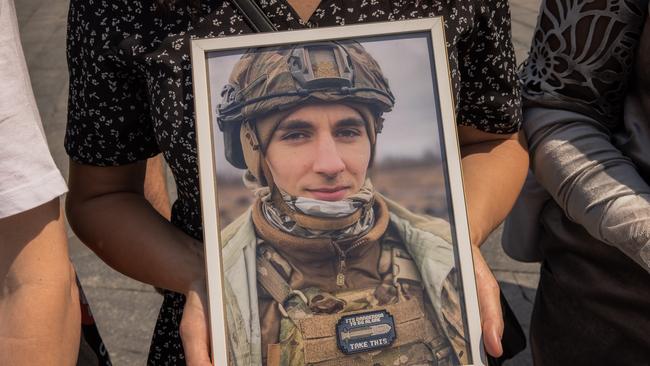 A relative holds a portrait of a Ukrainian servicemen during a rally demanding to create a National Military Cemetery in Kyiv, Ukraine. Picture: Roman Pilipey/Getty Images