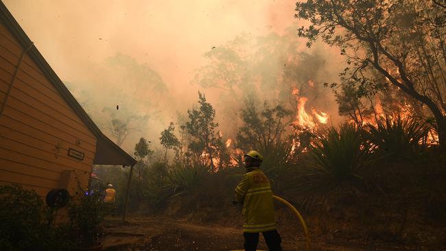 NSW Rural Fire Service and Fire and Rescue NSW crews work to protect a property on Kyola Road in Kulnura. Picture: AAP/Dan Himbrechts