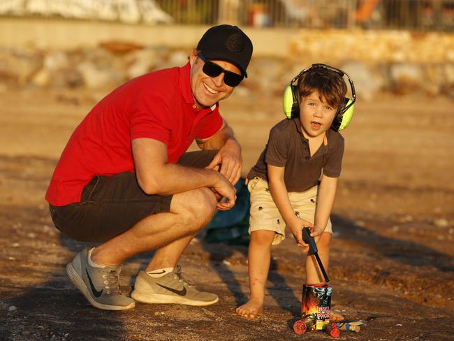 Aaron McMahon and son Jacob, 3, prepare to let off a firework during Territory Day celebrations. Picture: Glenn Campbell