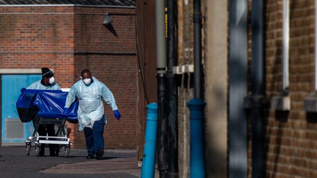 Hospital workers wheel a concealment trolley, typically used for transporting bodies, to the mortuary at Lewisham Hospital on April 16, 2020 in London.