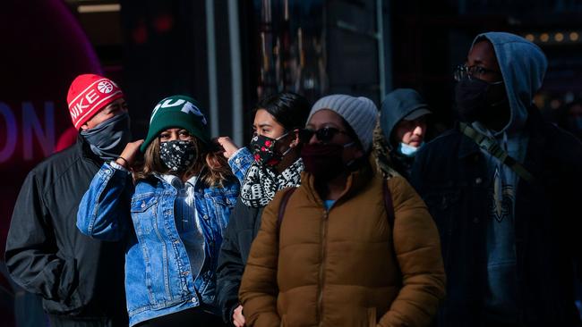 People wear face masks as they walk in Times Square in New York. Soon more than one in every 1,000 American’s will have died from COVID-19 in the space of one calendar year. Picture: AFP