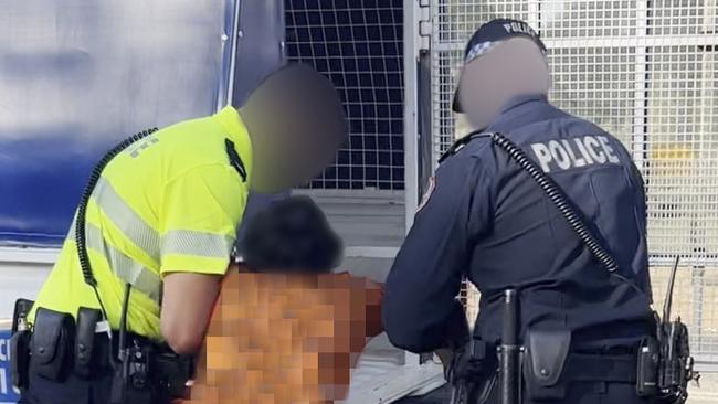 Eleven-year-old Benny struggles with Northern Territory police before being dragged into a paddy wagon on Friday.