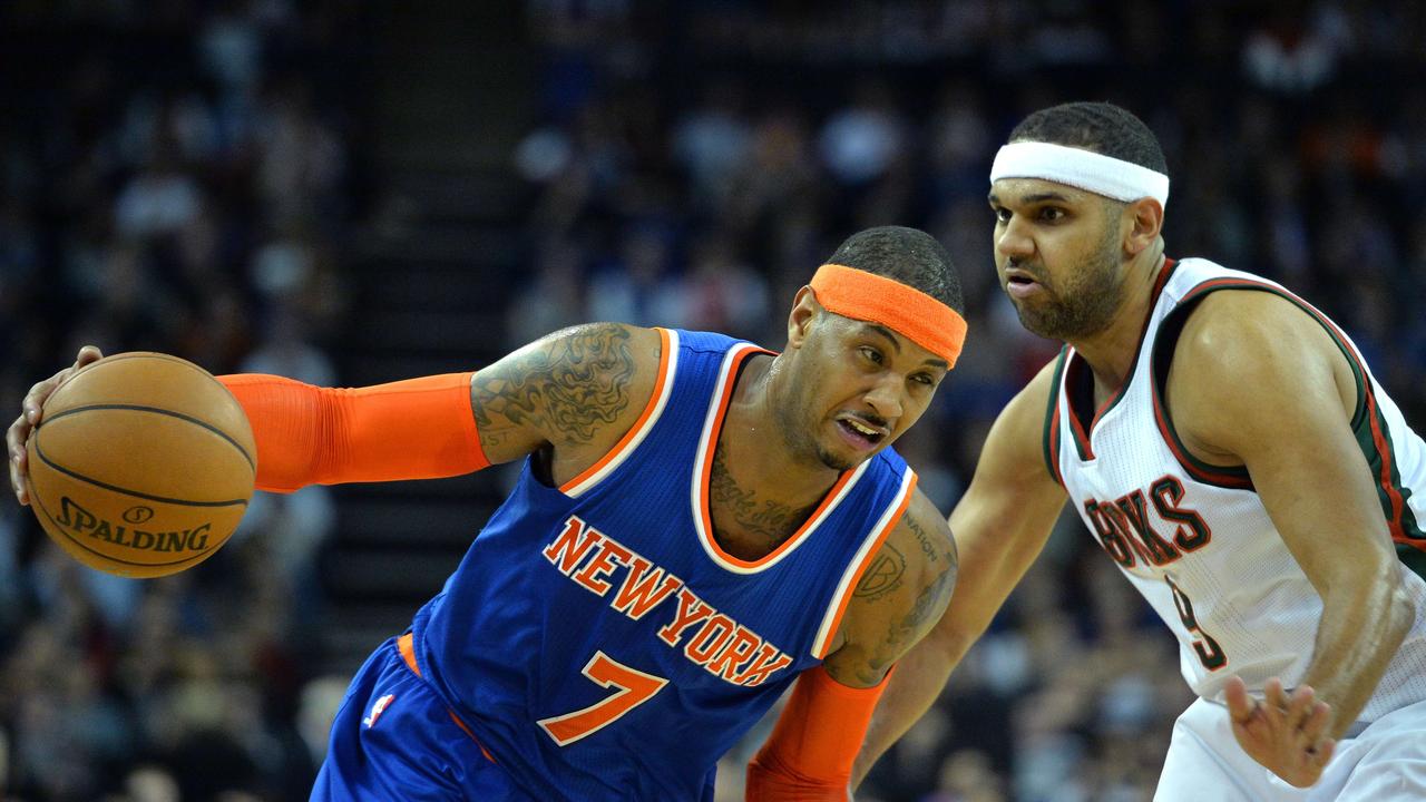 New York Knicks' Carmelo Anthony (L) runs past Milwaukee Bucks' Jared Dudley (R) during the 2015 NBA global game between Milwaukee Bucks and New York Knicks at the O2 Arena in London on January 15, 2015. AFP PHOTO / GLYN KIRK