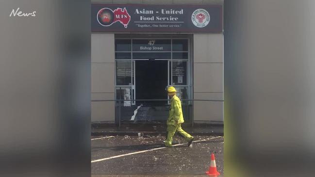 Water pours from Asian United Food Service building