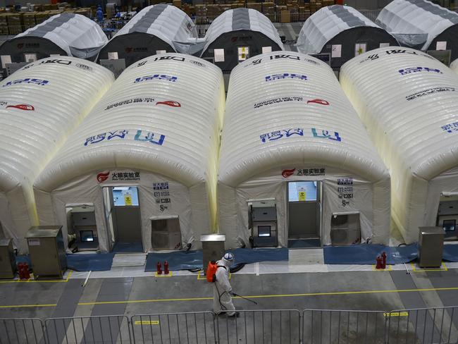 A staff member spraying disinfectant at a temporary "Fire Eye" laboratory used for coronavirus testing in Nanjing where Delta outbreaks are mushrooming. Picture: AFP / China OUT