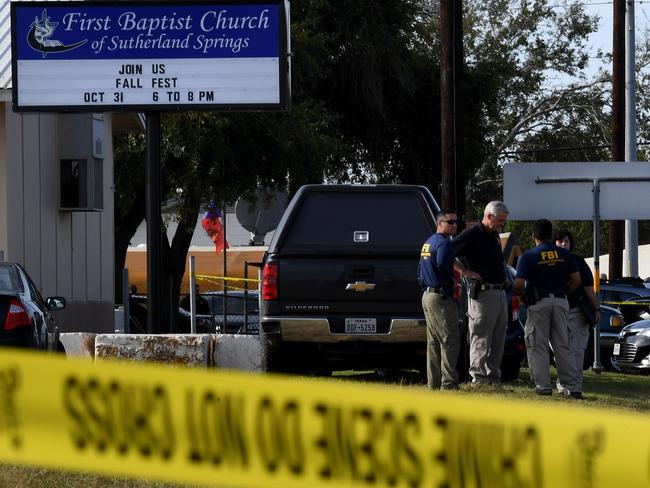 FBI agents search for clues at the entrance to the First Baptist Church. Picture: AFP