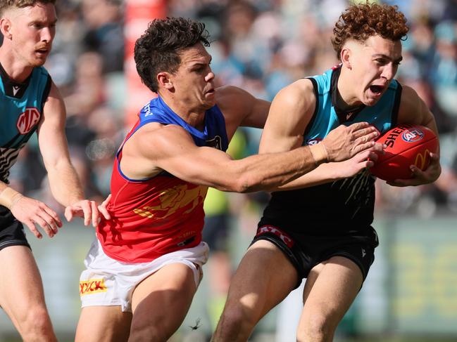 Port Adelaide’s Logan Evans is tackled by Brisbane’s Cam Rayner during his AFL debut in Round 15 at Adelaide Oval. Picture: James Elsby/AFL Photos via Getty Images