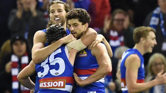 MELBOURNE, AUSTRALIA - JUNE 24:  Caleb Daniel, Marcus Bontempelli and Tom Liberatore of the Bulldogs celebrate winning the round 14 AFL match between the Western Bulldogs and the North Melbourne Kangaroos at Etihad Stadium on June 24, 2017 in Melbourne, Australia.  (Photo by Quinn Rooney/Getty Images)