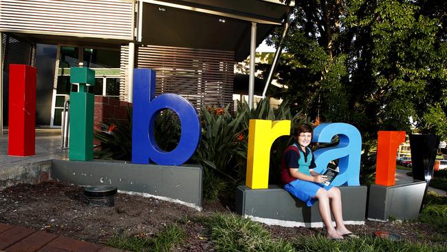 The Gold Coast City Council are looking into ways to commercialise their libraries for financial benefits - Jacob de Vere-Topham (11) from Pacific Pines reading a book out of front of the Nerang Library